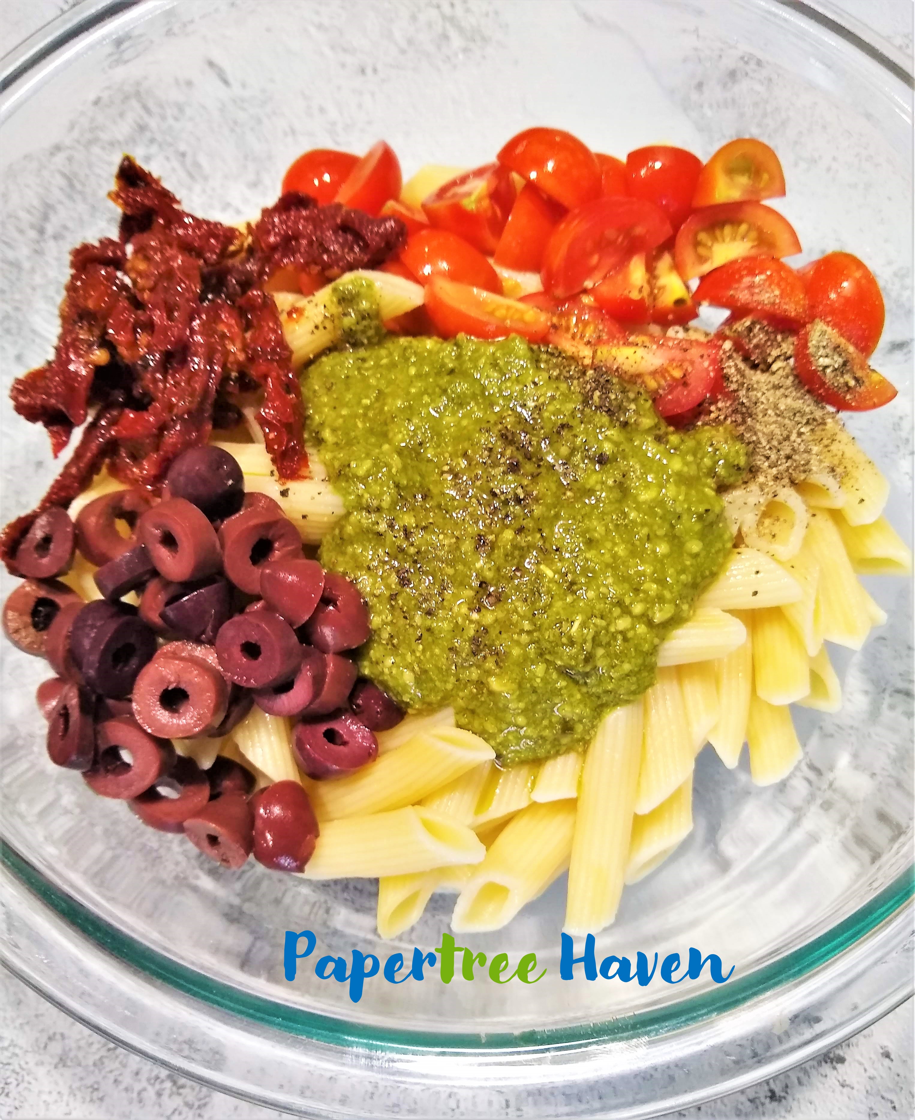 ingredients for pesto pasta with tomatoes and olives